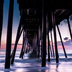 Low angle view of pier over sea against sky