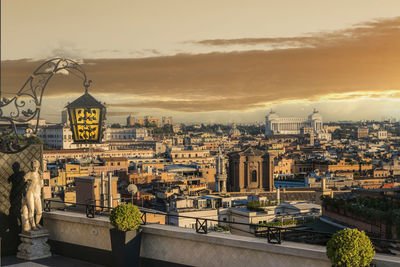 Illuminated buildings in city against sky during sunset