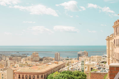 High angle view of buildings and sea against sky