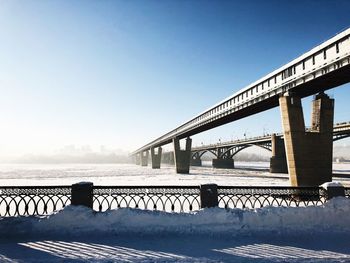 Bridge over river against sky during winter