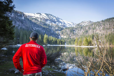 Rear view of person standing on snow covered mountain