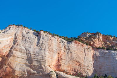 Low angle landscape of orange and white stone hillside at checkerboard mesa in zion national park