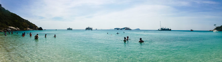 People enjoying in sea against sky