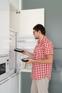 Midsection of man holding while standing at home