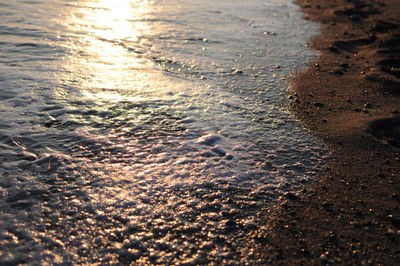Close-up of sand at beach during sunset