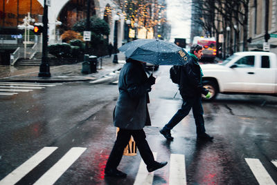 People walking on wet street during rainy season