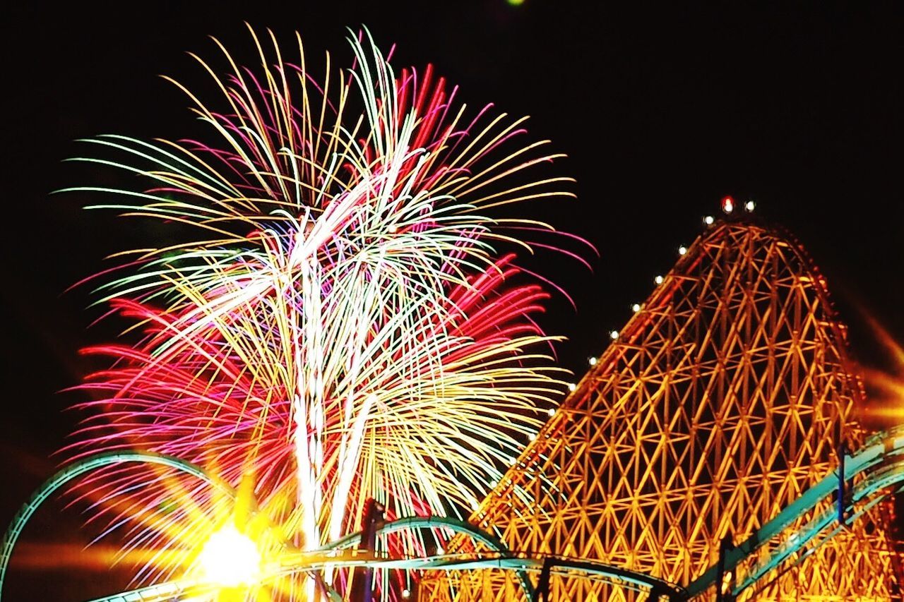 illuminated, night, arts culture and entertainment, low angle view, celebration, firework display, long exposure, multi colored, motion, exploding, glowing, firework - man made object, ferris wheel, clear sky, sky, blurred motion, built structure, amusement park, architecture, event