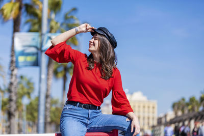 Smiling teenage girl wearing red top in city during sunny day