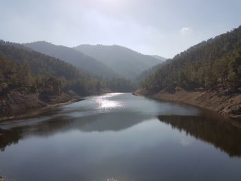 Scenic view of lake and mountains against sky