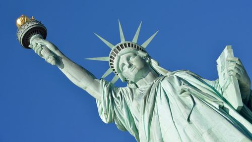 Low angle view of statue against blue sky