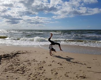 Man surfing on beach against sky