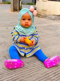 Portrait of cute baby girl and small corn