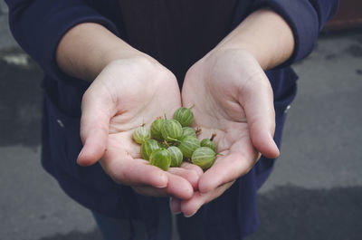 Girl holding a handful of gooseberries