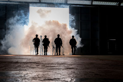 Silhouette army soldiers walking by tear gas walking on floor