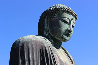 Low angle view of statue against clear blue sky