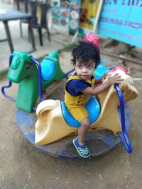 Cute girl sitting on outdoor play equipment