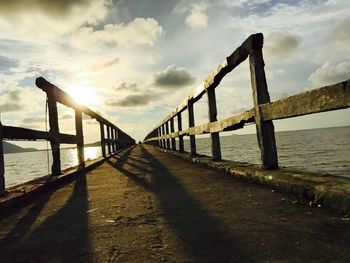 Pier over sea against sky during sunset