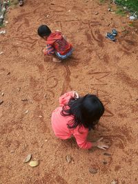 High angle view of girl and daughter on sand