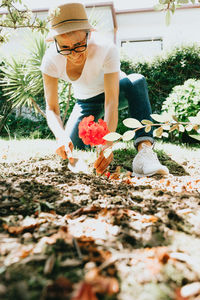 Rear view of woman picking flowers