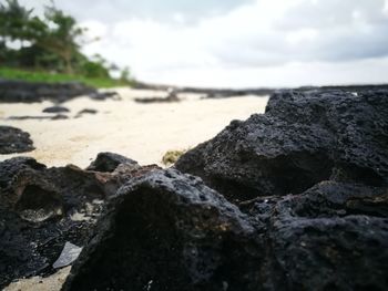 Close-up of rocks on beach against sky