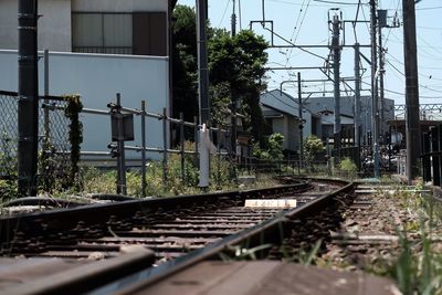 Railroad tracks by building against sky