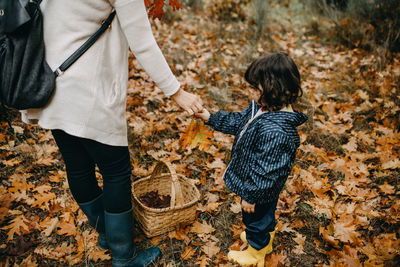 Mother give autumn leave to daughter