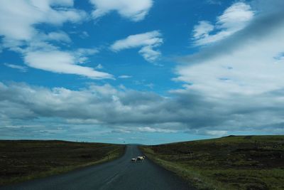 Road amidst landscape against blue sky