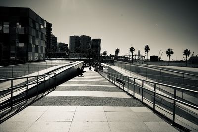 Footpath amidst buildings in city against sky