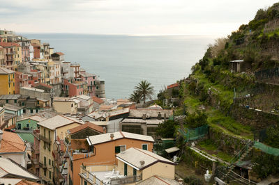 High angle view of houses by sea against sky