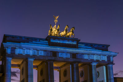 Statue in city at night