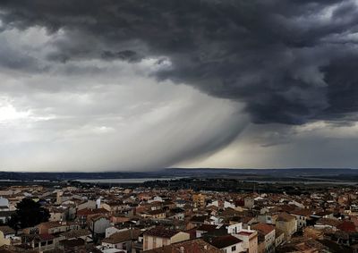 Aerial view of townscape by sea against sky
