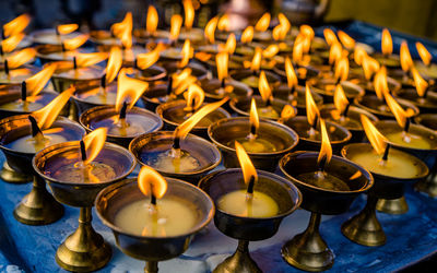 Close-up of lit tea candles in temple