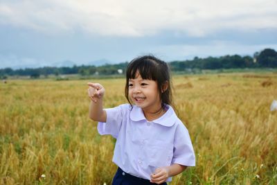 Portrait of smiling girl standing in field