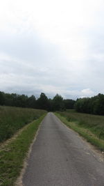 Road amidst field against sky