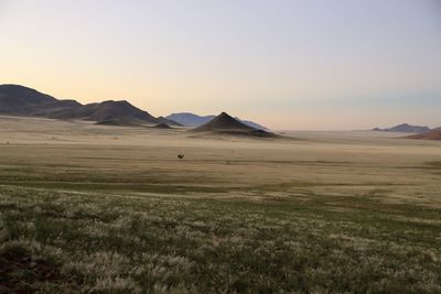 Scenic view of desert against sky during sunset