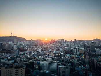 High angle view of modern buildings against sky during sunset