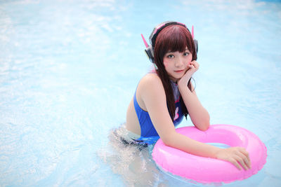 Portrait of young woman swimming in sea