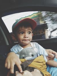 Portrait of cute boy sitting in car