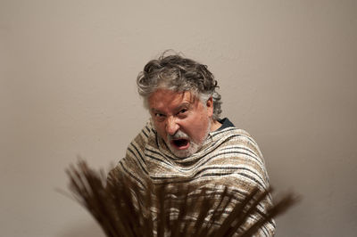 Portrait of man looking away against wall