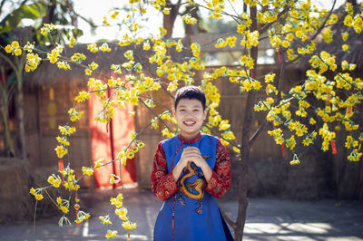 Portrait of boy standing against plants