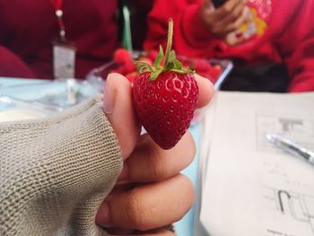 Close-up of hand holding strawberries