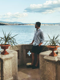 Man standing by sea against sky