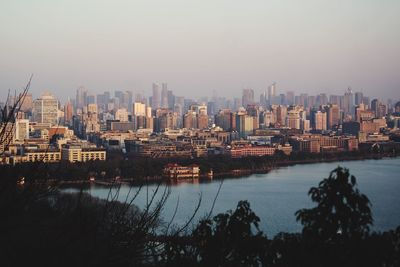 City at waterfront against clear sky