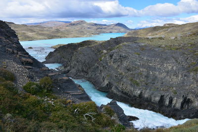 Scenic view of river and mountains against sky