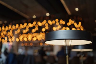 Close-up of illuminated lighting equipment hanging on ceiling