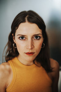 Portrait of young woman against wall