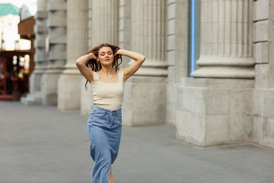 Young woman standing against wall