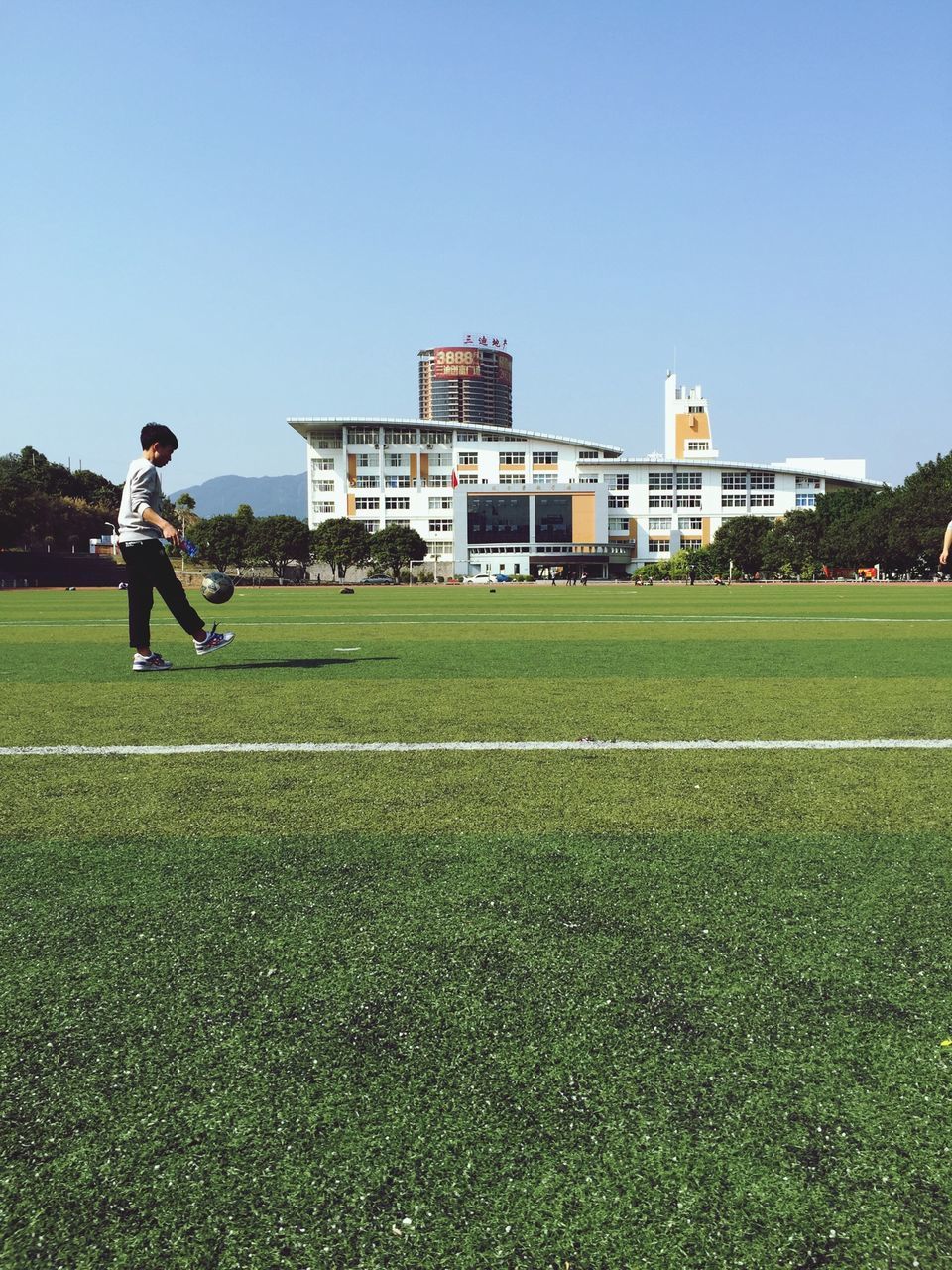 grass, clear sky, lifestyles, leisure activity, full length, copy space, architecture, building exterior, field, green color, built structure, casual clothing, men, grassy, blue, boys, walking, childhood
