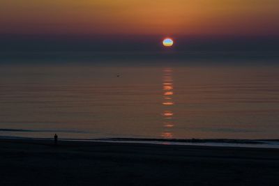 Scenic view of sea against orange sky