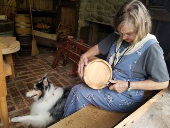 Senior woman holding container by dog